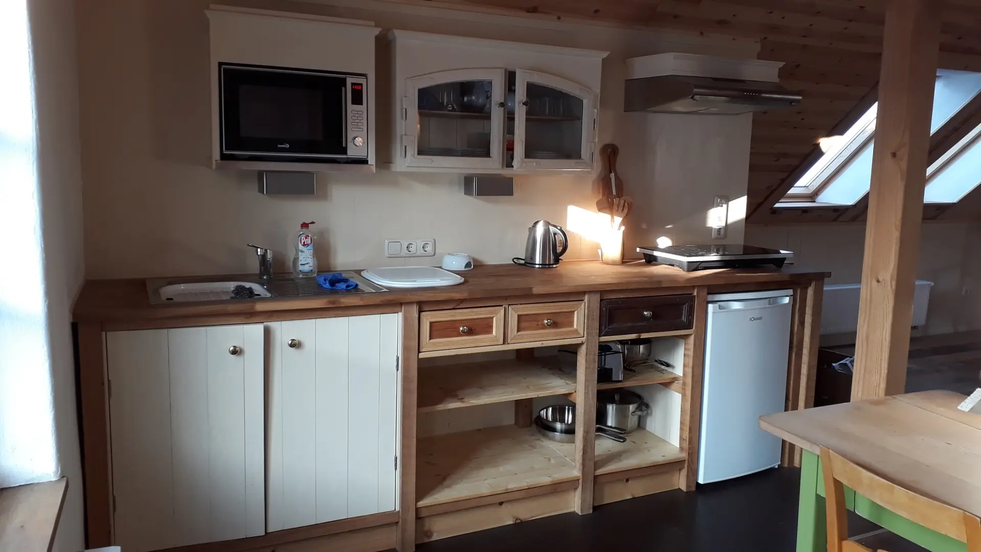 Küchenzeile mit Arbeitsfläche, Herdplatten und Mikrowellenofen