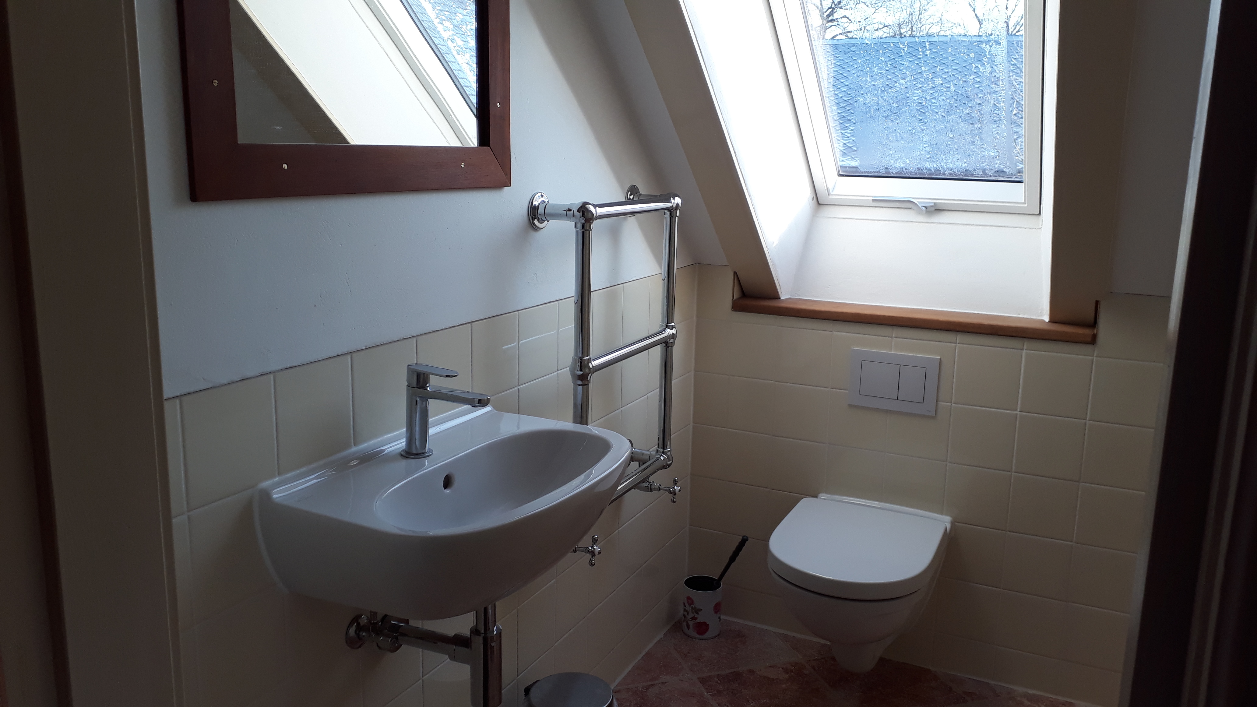 Bad: Waschbecken, Toilette und Dachfenster sind zu sehen.