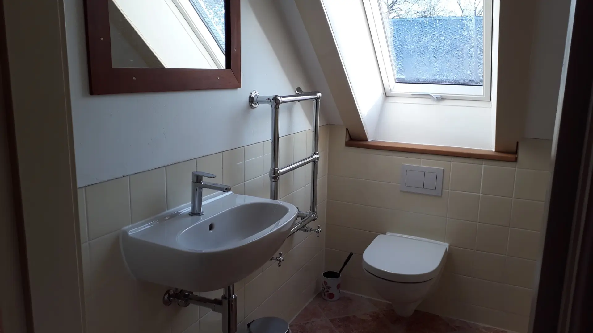 Bad: Waschbecken, Toilette und Dachfenster sind zu sehen.