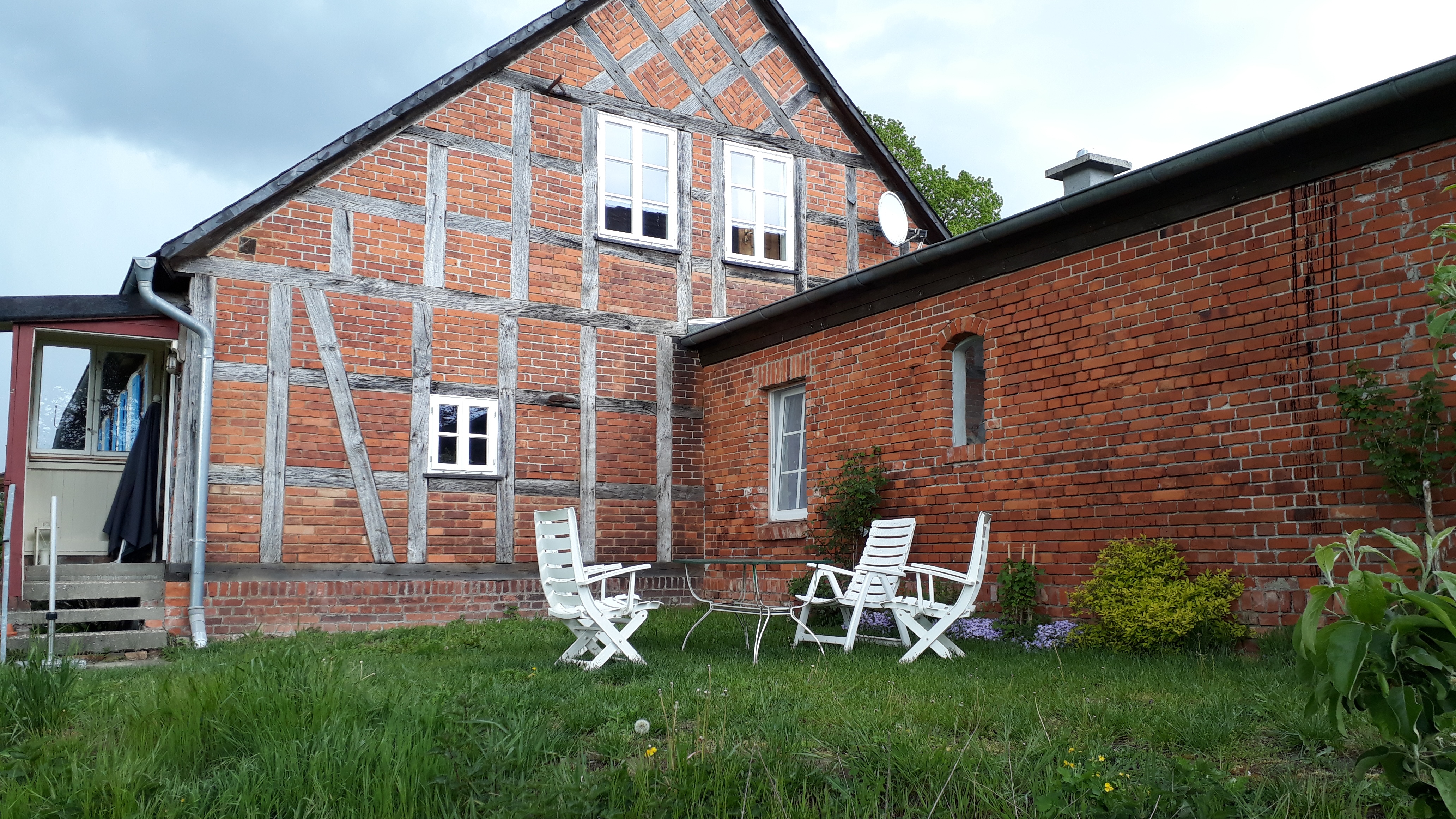 Terasse der Ferienwohnung im Grünen mit Sicht auf das Fachwerkhaus und die Weide, welche bei Zeiten von Zebu-Rindern bewohnt wird.
